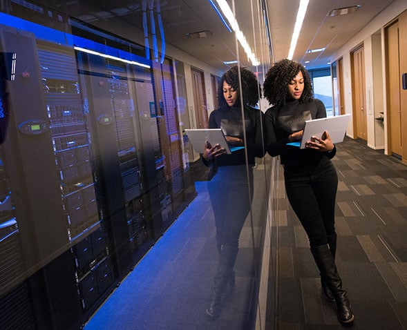 Woman standing with a laptop.