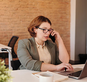 woman talking on phone at computer