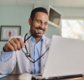 doctor-computer-holding-glasses